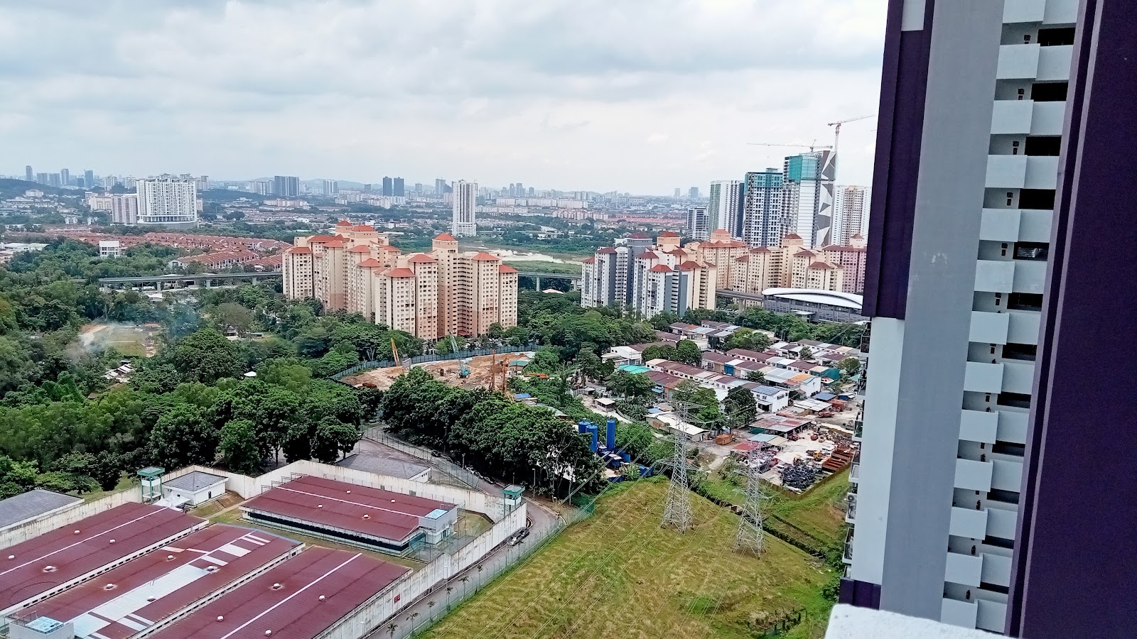 Residensi Jalilmas @ Bukit Jalil: A high-angle view from a residential unit showing a dense urban landscape with surrounding towers, low-rise housing, and construction sites under an overcast sky.