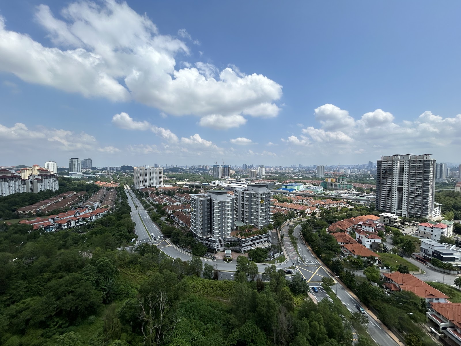 Condominium Akasia Bukit Jalil: Aerial view from a high vantage point overlooking the urban landscape of Bukit Jalil, featuring residential areas, highways, and the city skyline in the distance under a partly cloudy sky.