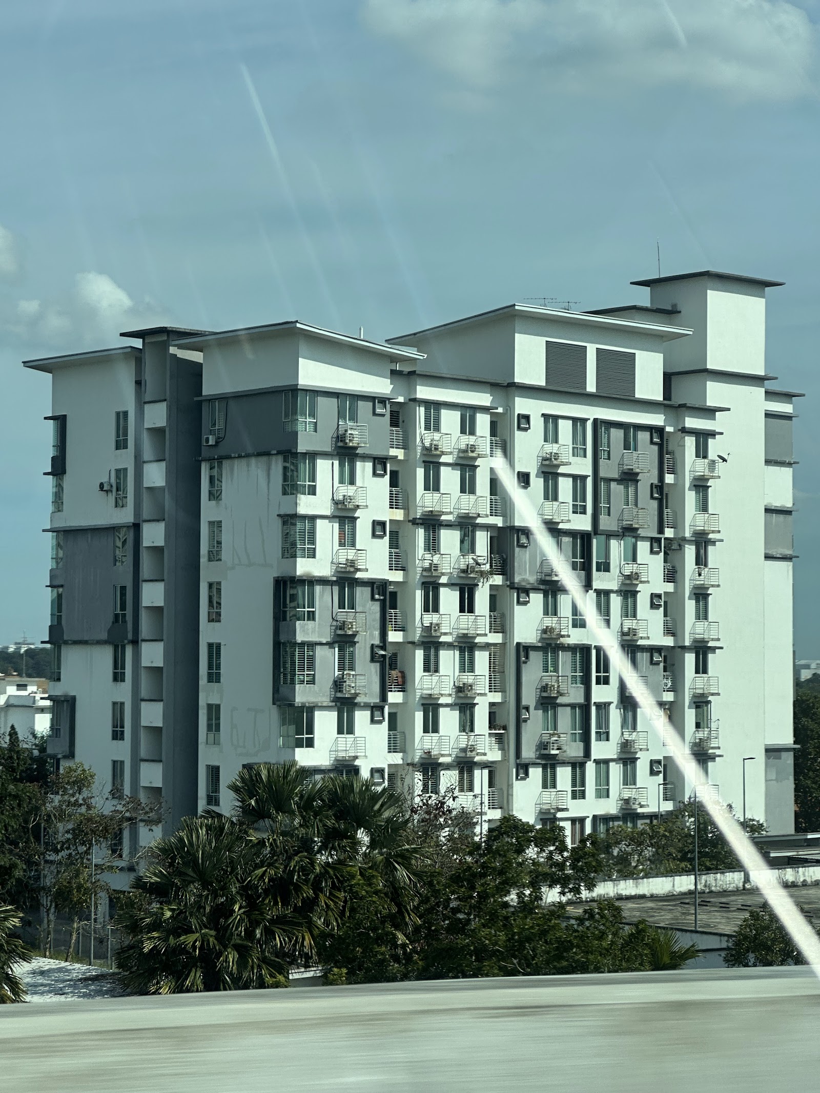 Suria Apartment @ Kota Damansara: A view of the exterior facade of a high-rise apartment building, taken from the side, possibly through a window given the reflection artifacts.