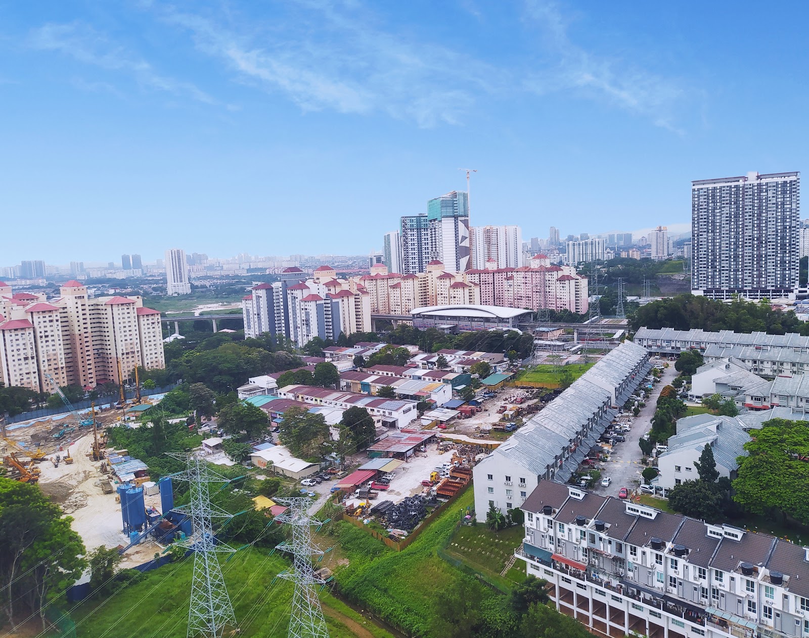 Residensi Jalilmas @ Bukit Jalil: An aerial view of a residential and industrial area looking towards a city skyline with high-rise buildings and a sports stadium in the distance.