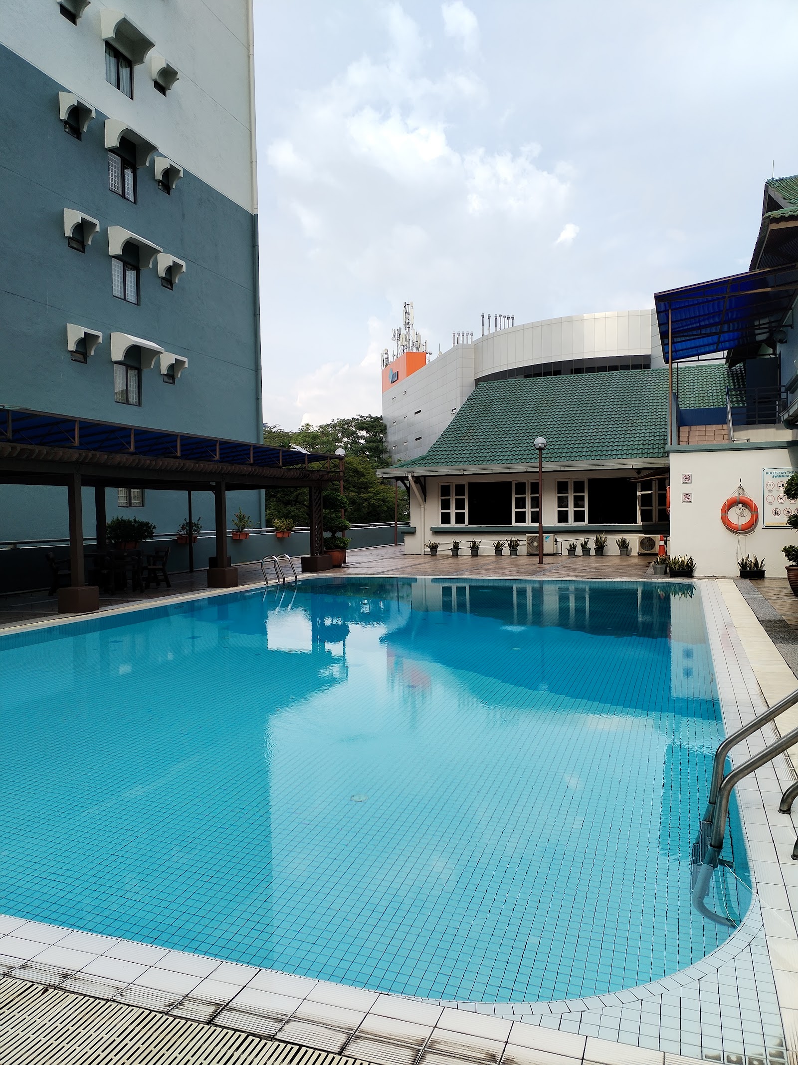 Vista Komanwel B: An outdoor swimming pool at a residential development with a lifebuoy and a covered walkway.