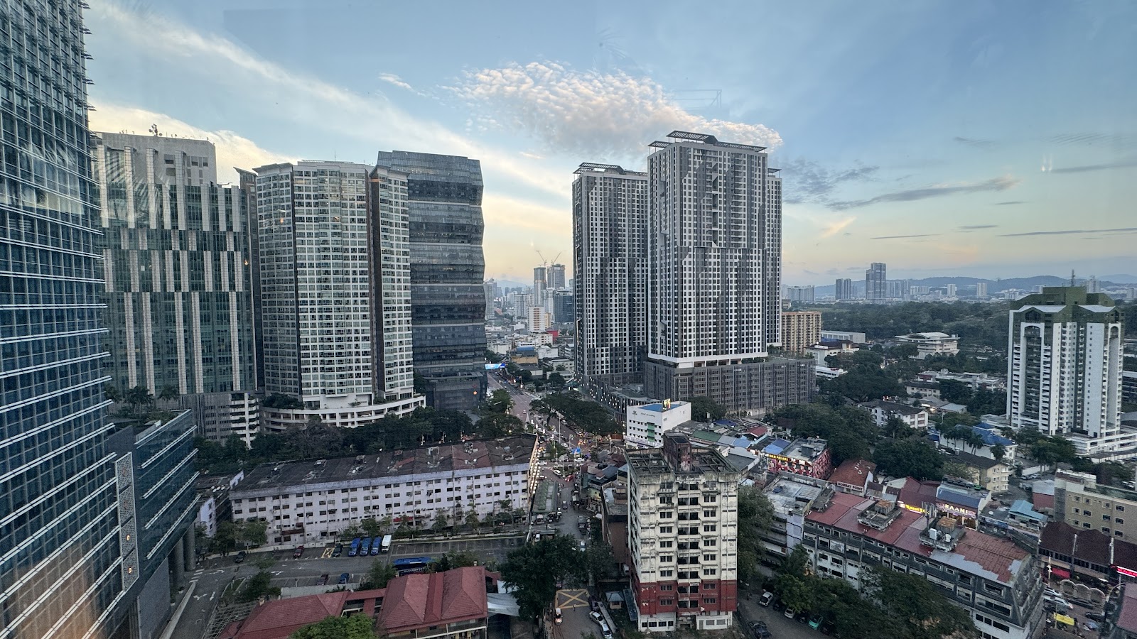 Mutiara Residency: An elevated view overlooking a mix of high-rise residential towers and older commercial buildings in a city during late afternoon.
