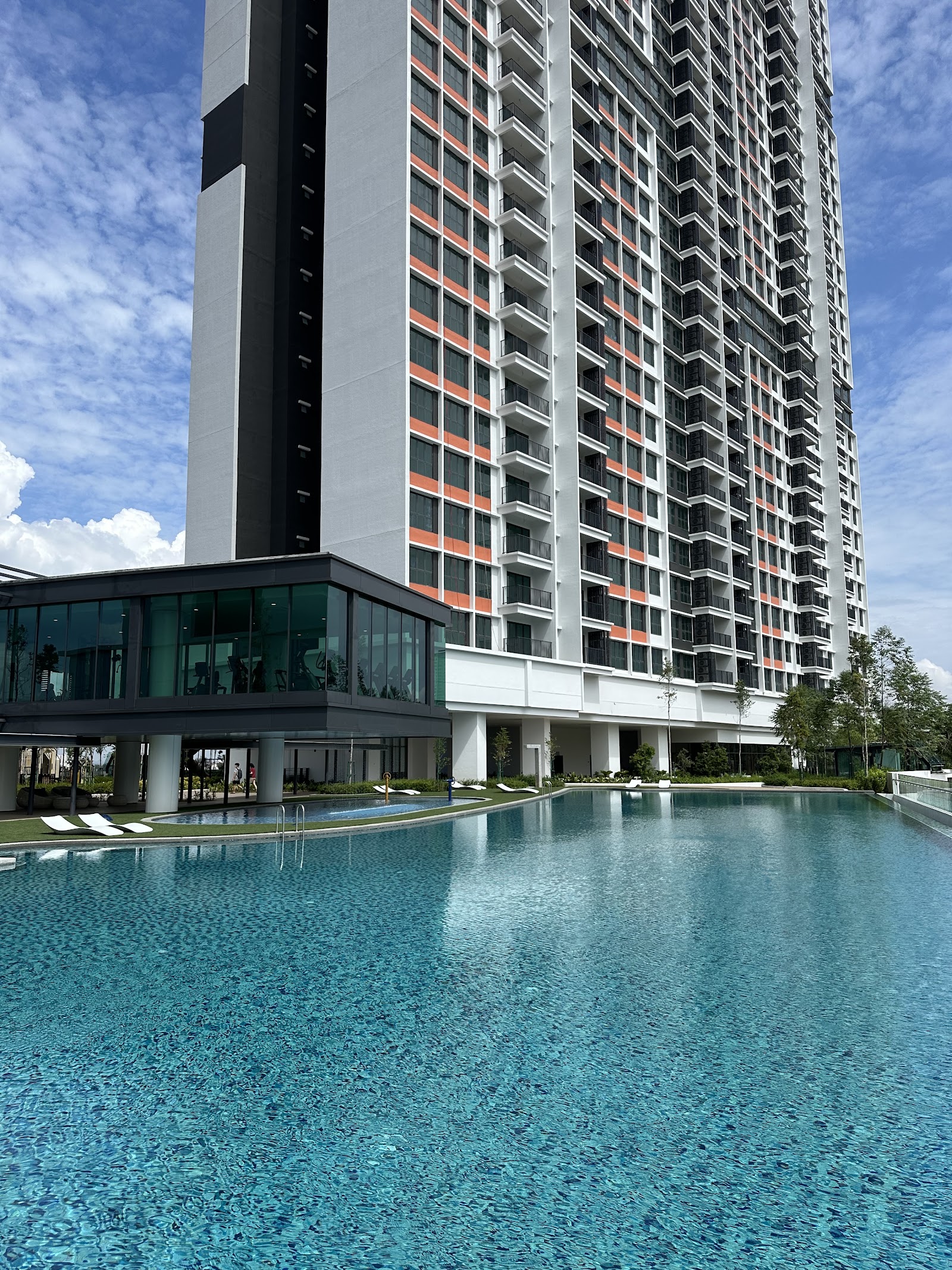 SUNWAY D'HILL RESIDENCES, PETALING JAYA: An outdoor swimming pool and leisure deck situated in the foreground, with a tall residential building in the background.