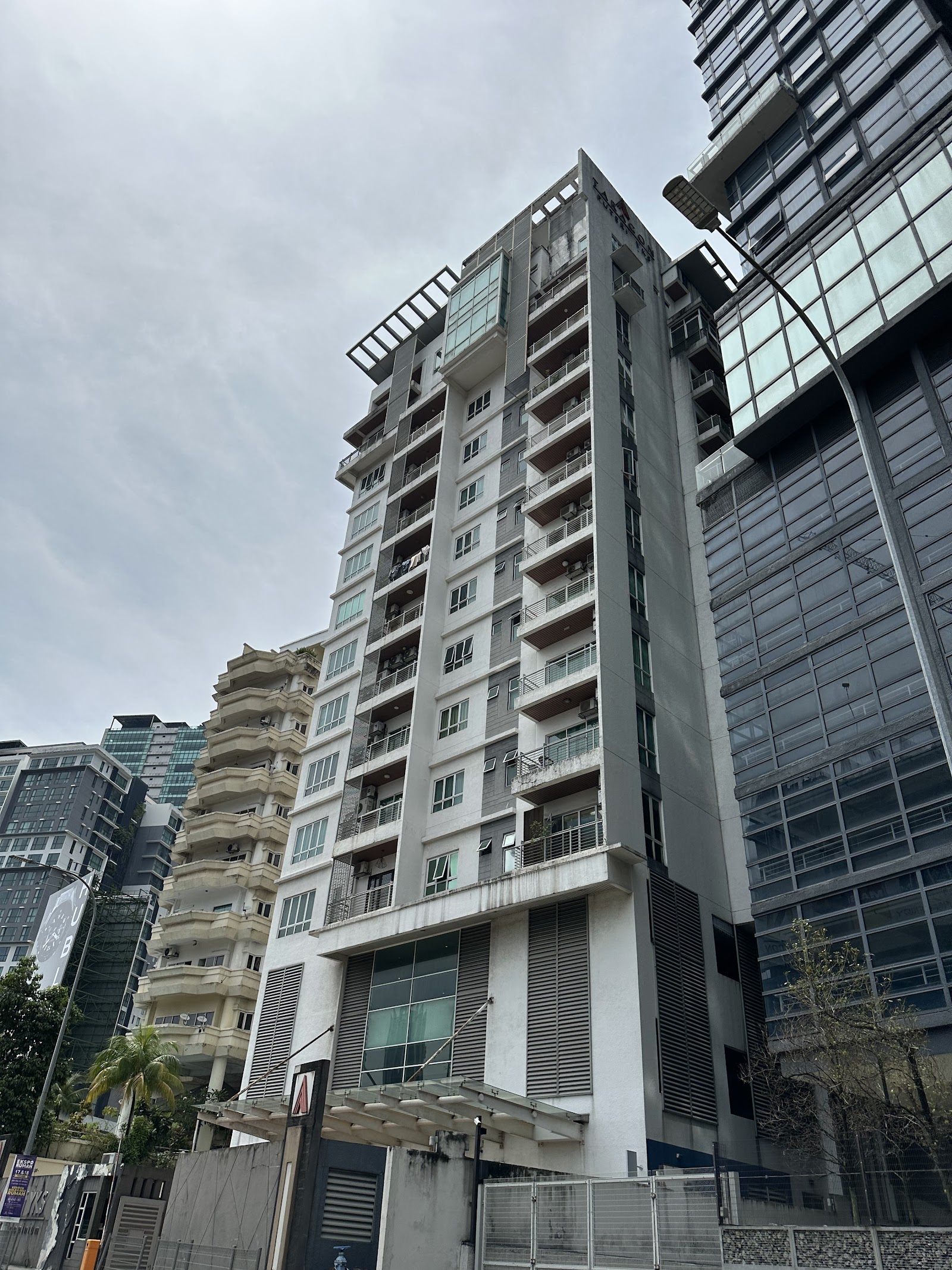 Taragon Puteri YKS: The exterior facade of a multi-story residential building, showing its balconies, windows, and structure from a low angle against an overcast sky.