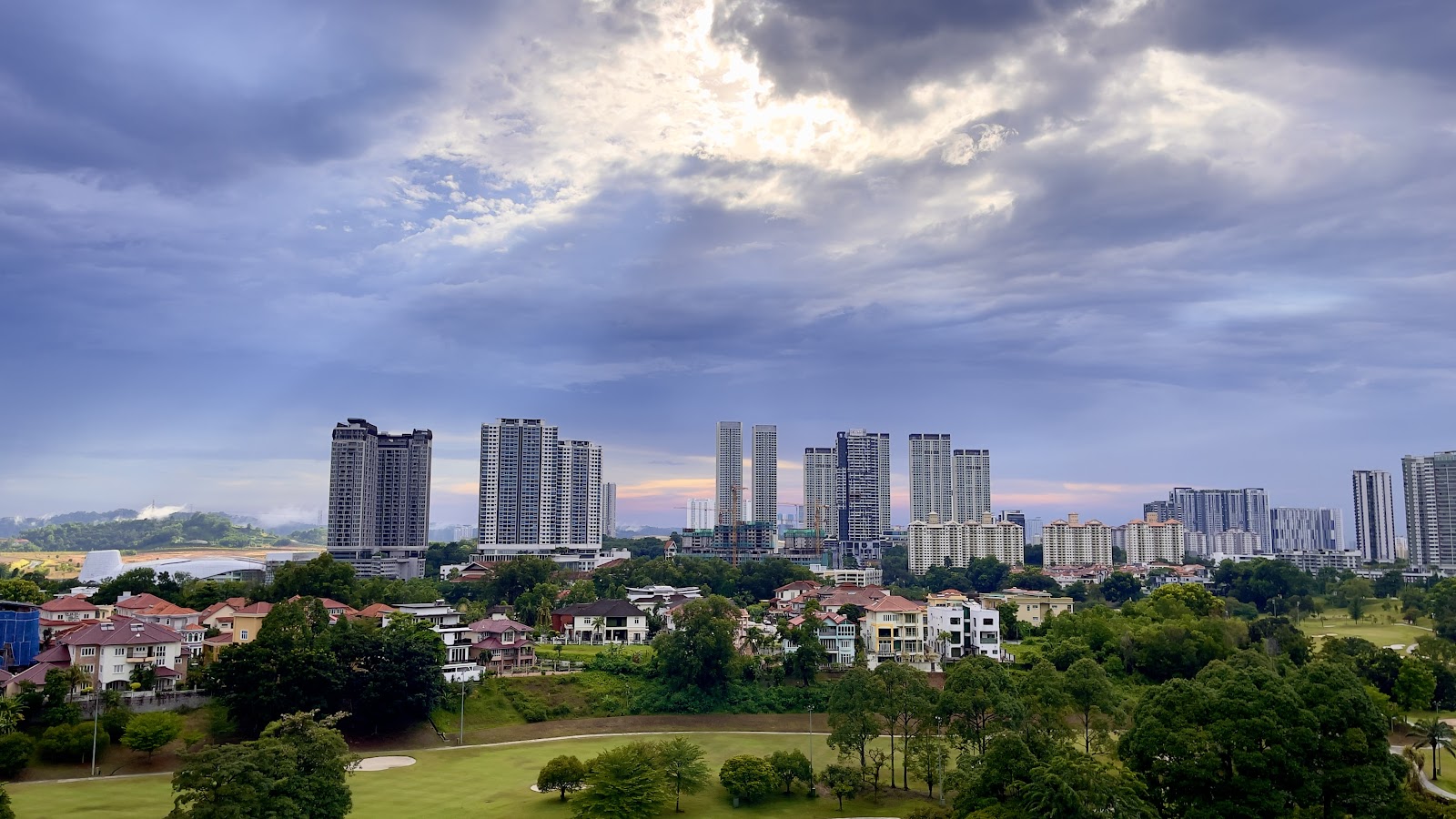 Savanna: A panoramic view from an elevated position, looking out over a residential neighborhood and a cluster of high-rise apartment towers under a cloudy sky.