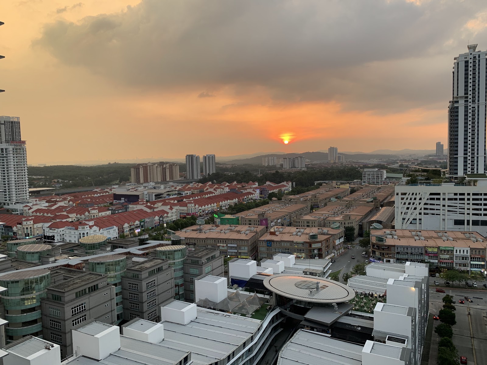 Cascades Residency: A panoramic view of a city skyline at sunset, featuring residential buildings and high-rises.