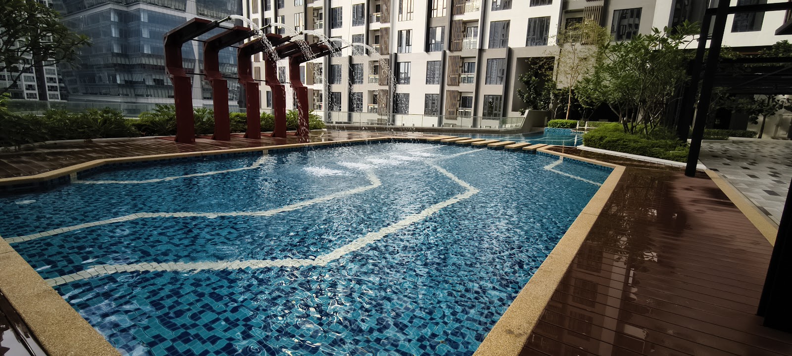 Sentral Suites: A swimming pool with a water feature in the landscaped grounds of a residential development.