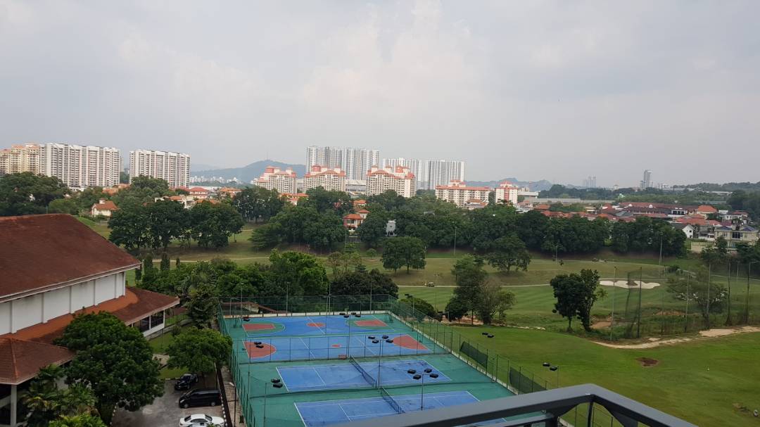The Link 2: A panoramic view of a residential area and green landscape seen from an elevated position, featuring a tennis court in the foreground.