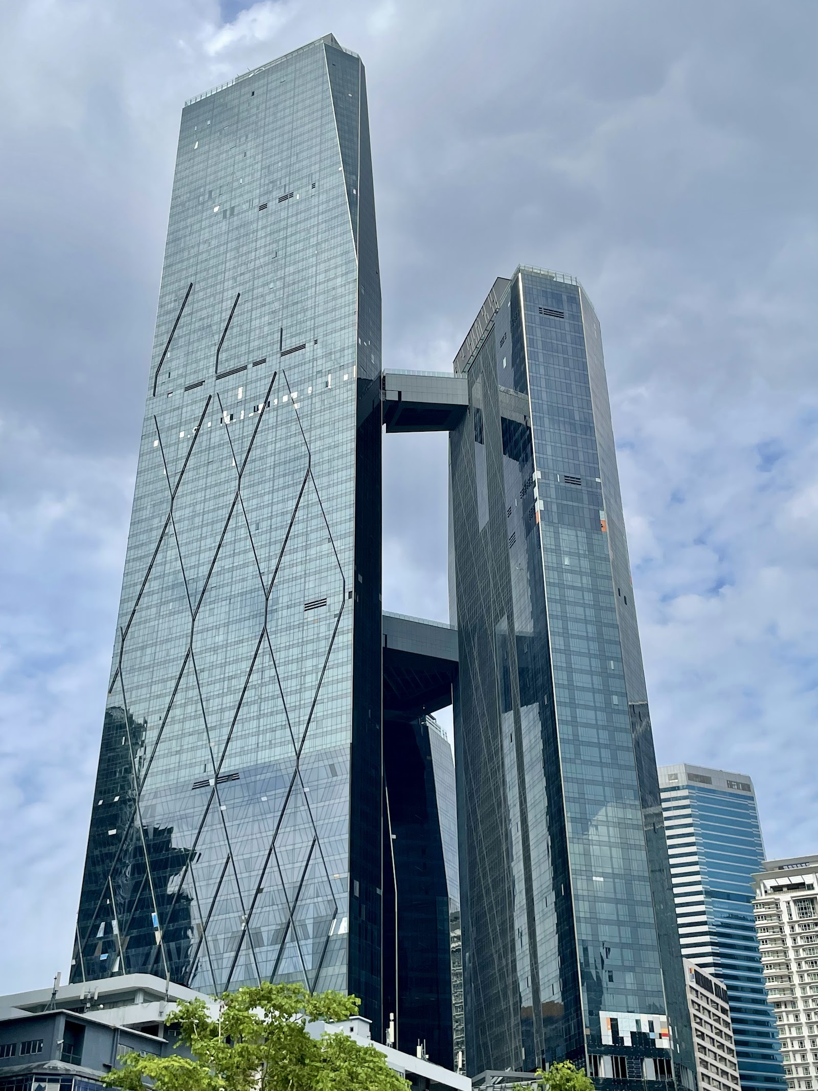 SO Sofitel: A low-angle view of the facade of the Guoco Tower, highlighting its two glass towers connected by sky bridges.