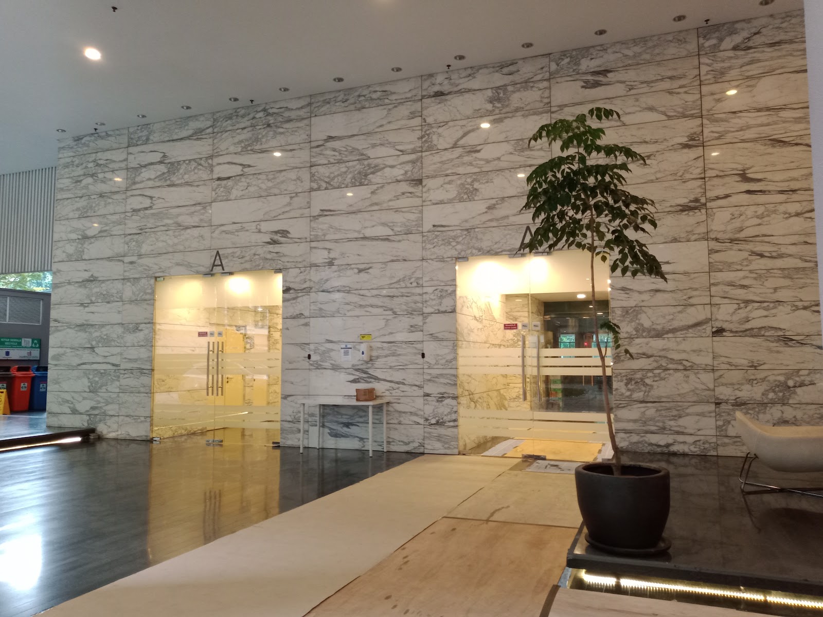 Bintang Goldhill: A large, modern lobby with a floor-to-ceiling marble wall and illuminated glass entryways.