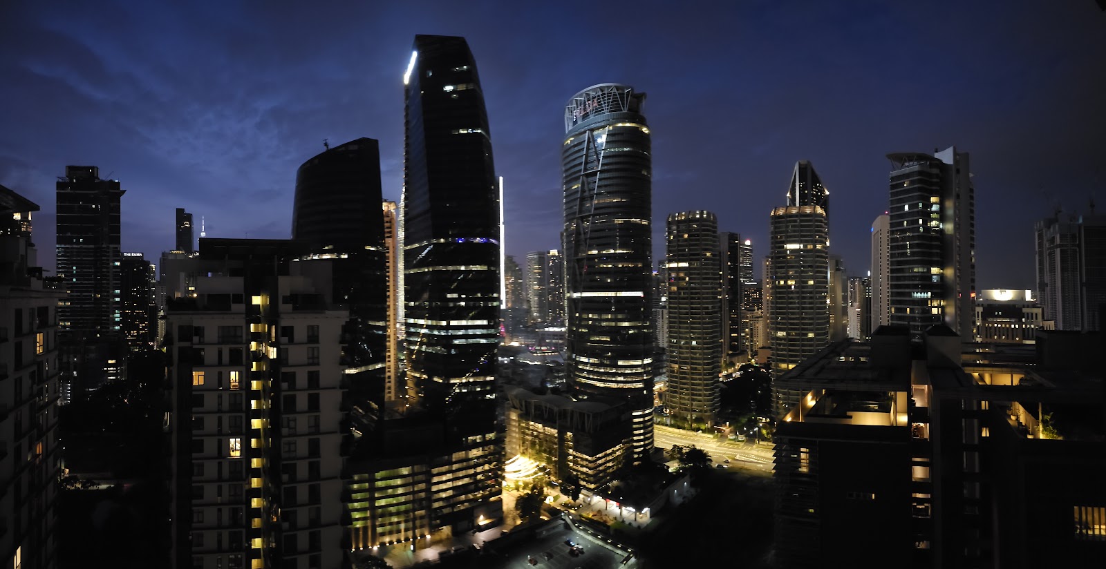 Stonor 3: A panoramic night view of a city skyline with illuminated skyscrapers and a major road.