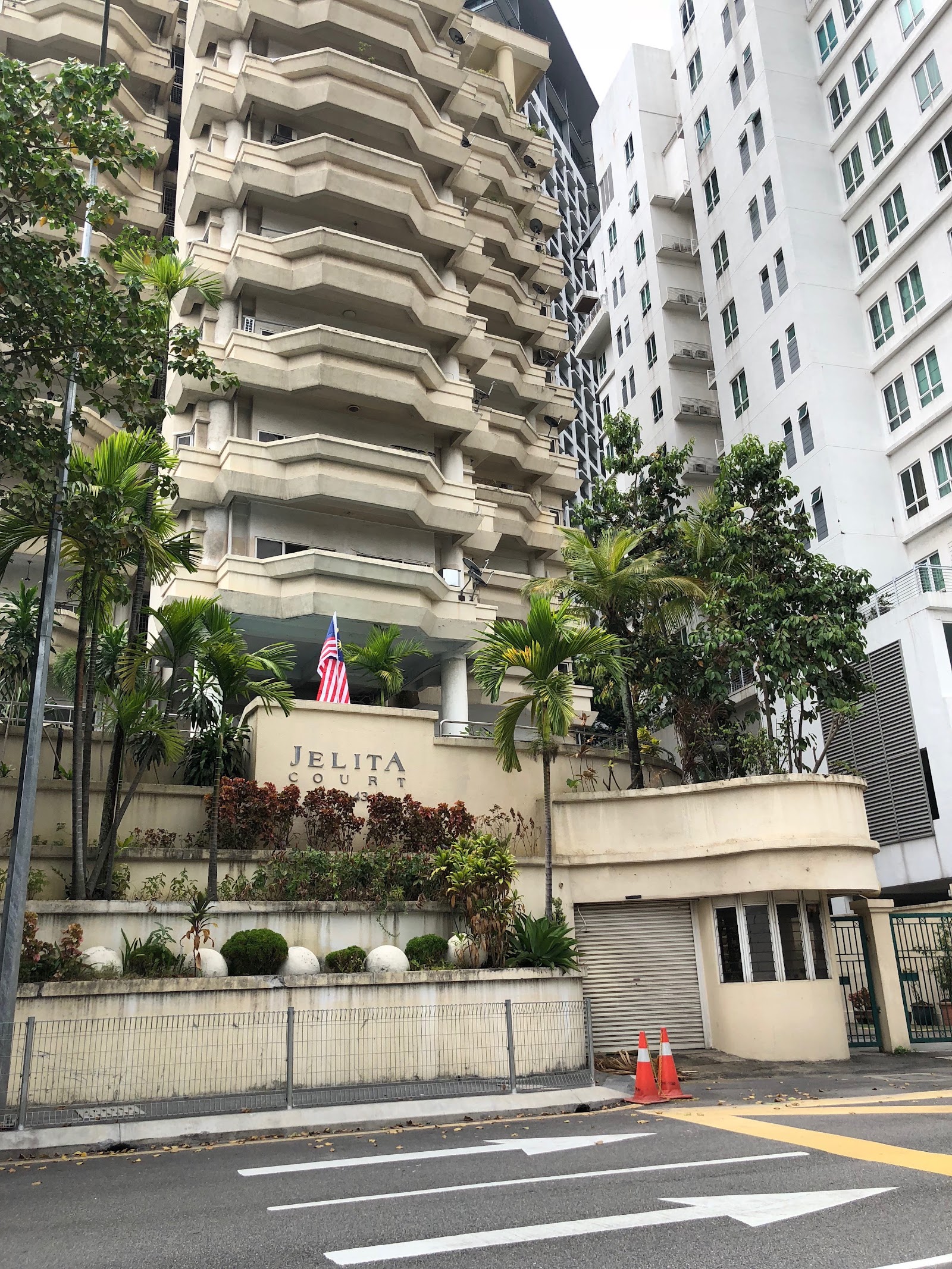 Jelita Court: A street-level view of the exterior of a residential building with distinctive geometric balconies, identified by signage as Jelita Court.