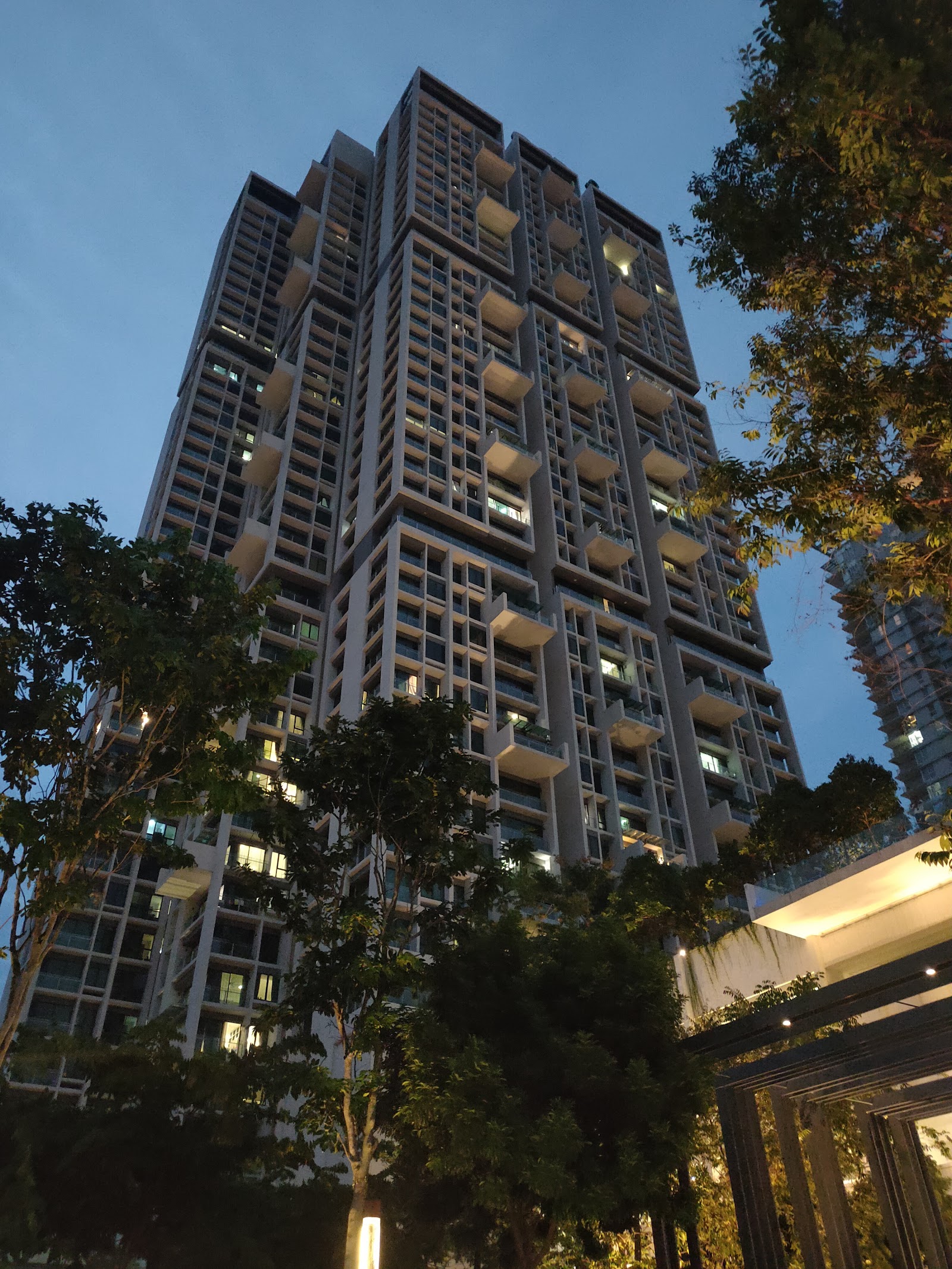 One Central Park @ Desa ParkCity: A low-angle view of a tall residential building with illuminated balconies against a dusk sky.