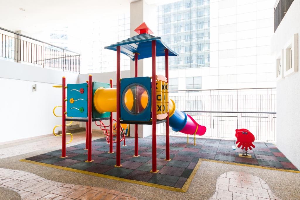 Seri Bukit Ceylon: A colorful children's playground structure with a slide and climbing features on a tiled patio.