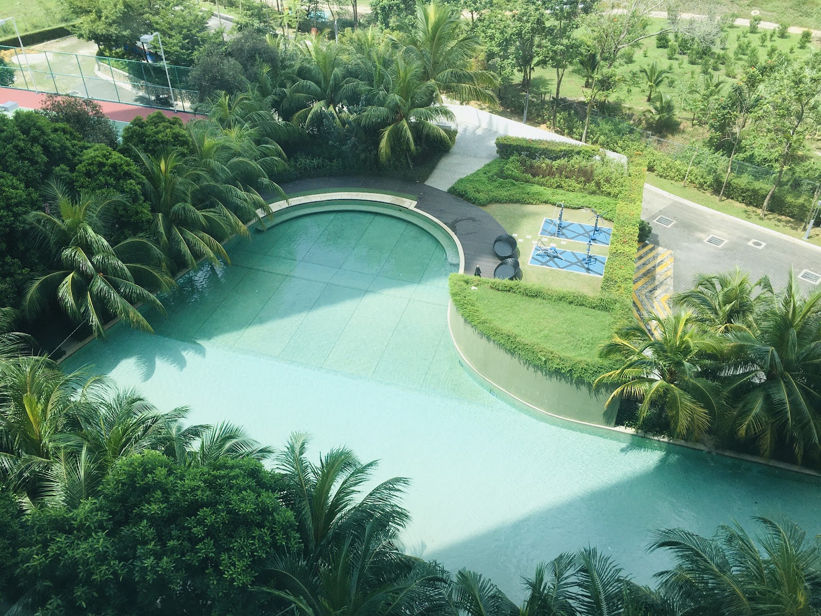 LaCosta, SUNWAY SOUTH QUAY: Aerial view of a kidney-shaped swimming pool and adjacent fitness area within a tropical landscaped garden.