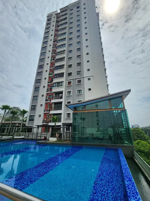 Savanna: An elevated swimming pool with blue mosaic tiles and a glass-enclosed room in front of a high-rise residential tower.