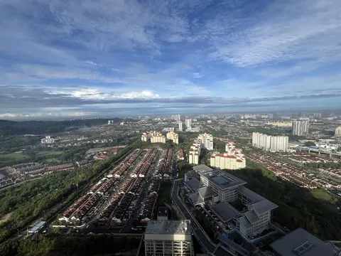 Mercu Jalil: A high-angle photograph showing a wide view of a city with residential housing, high-rise buildings, and a large institutional building in the foreground.