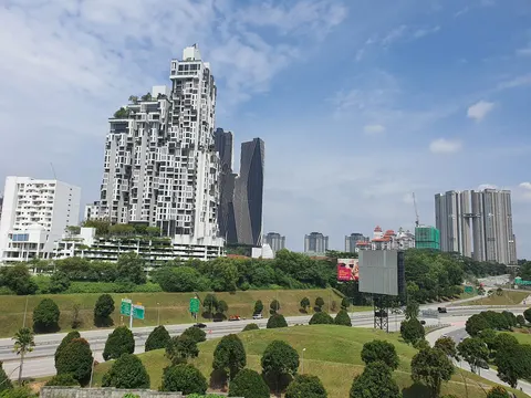 Prima Duta: A view of modern high-rise residential towers and a landscaped highway under a blue sky