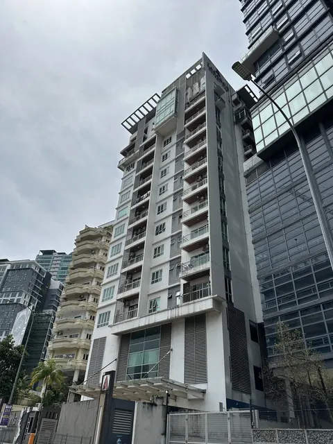 Taragon Puteri YKS: The exterior facade of a multi-story residential building, showing its balconies, windows, and structure from a low angle against an overcast sky.