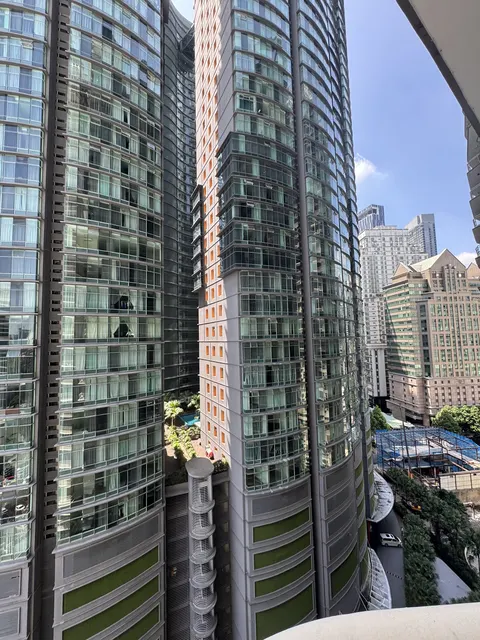 Idaman Residence: High-rise residential towers with glass facades and green accents, viewed from an exterior perspective.