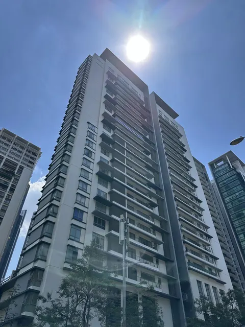 2 Hampshire: Low-angle view of a modern residential tower with white facade and balconies against a bright blue sky.
