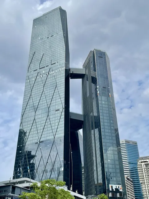 SO Sofitel: A low-angle view of the facade of the Guoco Tower, highlighting its two glass towers connected by sky bridges.
