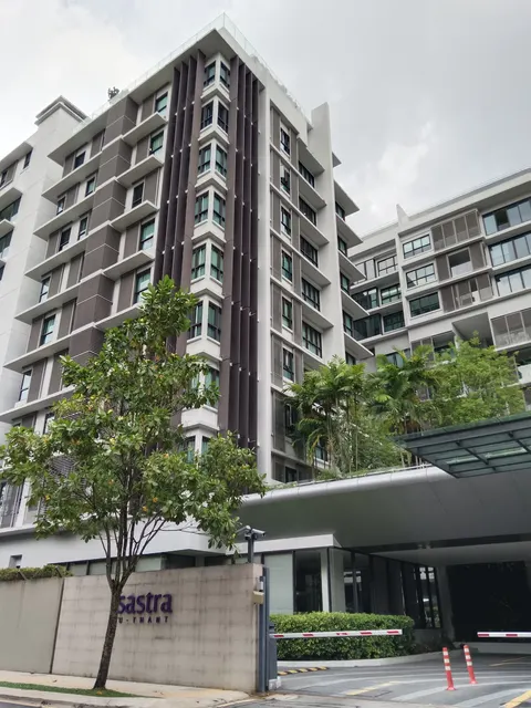 Sastra U-Thant: A low-angle exterior view of the Sastra U-Thant condominium complex, showing the multi-story building facade, entrance driveway, and surrounding landscaping.