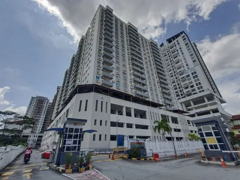 Kinrara Mas: Wide-angle view of the Kinrara Mas high-rise residential complex from its street-level entrance, showing the facade, ground floor, and gate area.