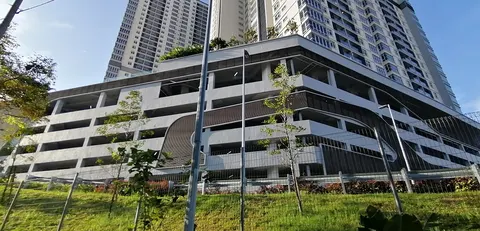 Paraiso Residence: Ground-level exterior of a multi-story podium building with a fenced yard and young trees in the foreground, supporting a high-rise residential tower.
