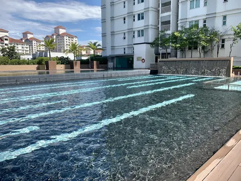 Mutiara Upper East: A wide swimming pool with lane markings, surrounded by white residential buildings and landscape features.