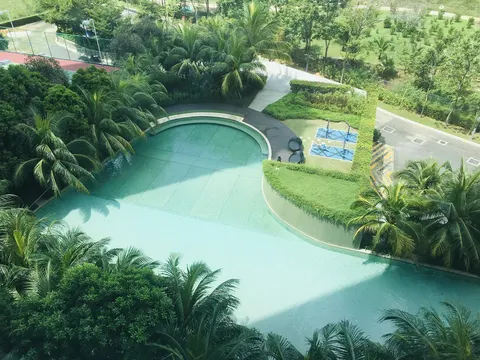 LaCosta, SUNWAY SOUTH QUAY: Aerial view of a kidney-shaped swimming pool and adjacent fitness area within a tropical landscaped garden.