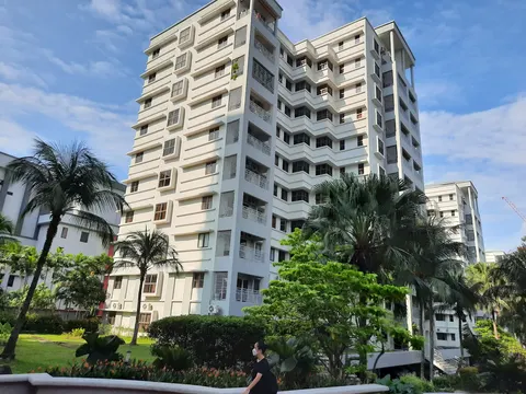 PALMVILLE RESORT CONDOMINIUM: Exterior view of the Palmville Resort Condominium buildings with surrounding landscaping and a pedestrian in the foreground.