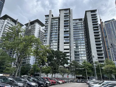 Park Seven: A row of parked cars in the foreground, with a line of trees and several high-rise apartment buildings in the background under a cloudy sky.