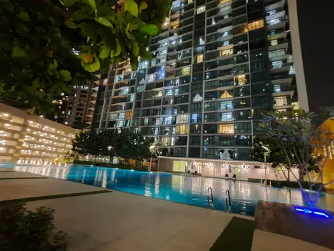 The Z Residence: A swimming pool at night with the illuminated facade of a residential high-rise in the background.