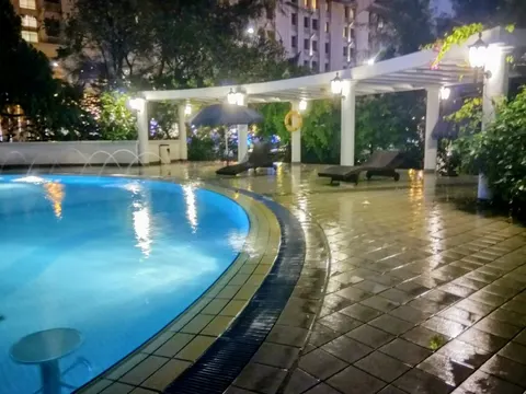 1A Stonor: An outdoor swimming pool at night, featuring illuminated water, a tiled deck, lounge chairs, and a covered pergola area with lighting.