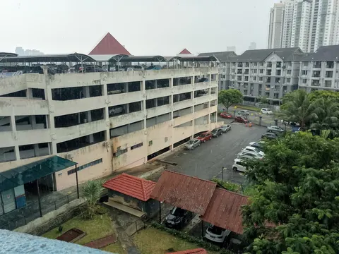 Ridzuan Condominium: A view of an apartment complex with a parking structure and grounds.