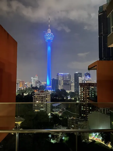 City Gardens Condominium: A night-time view of the Kuala Lumpur city skyline, featuring the blue-lit KL Tower, as seen from a balcony or window.