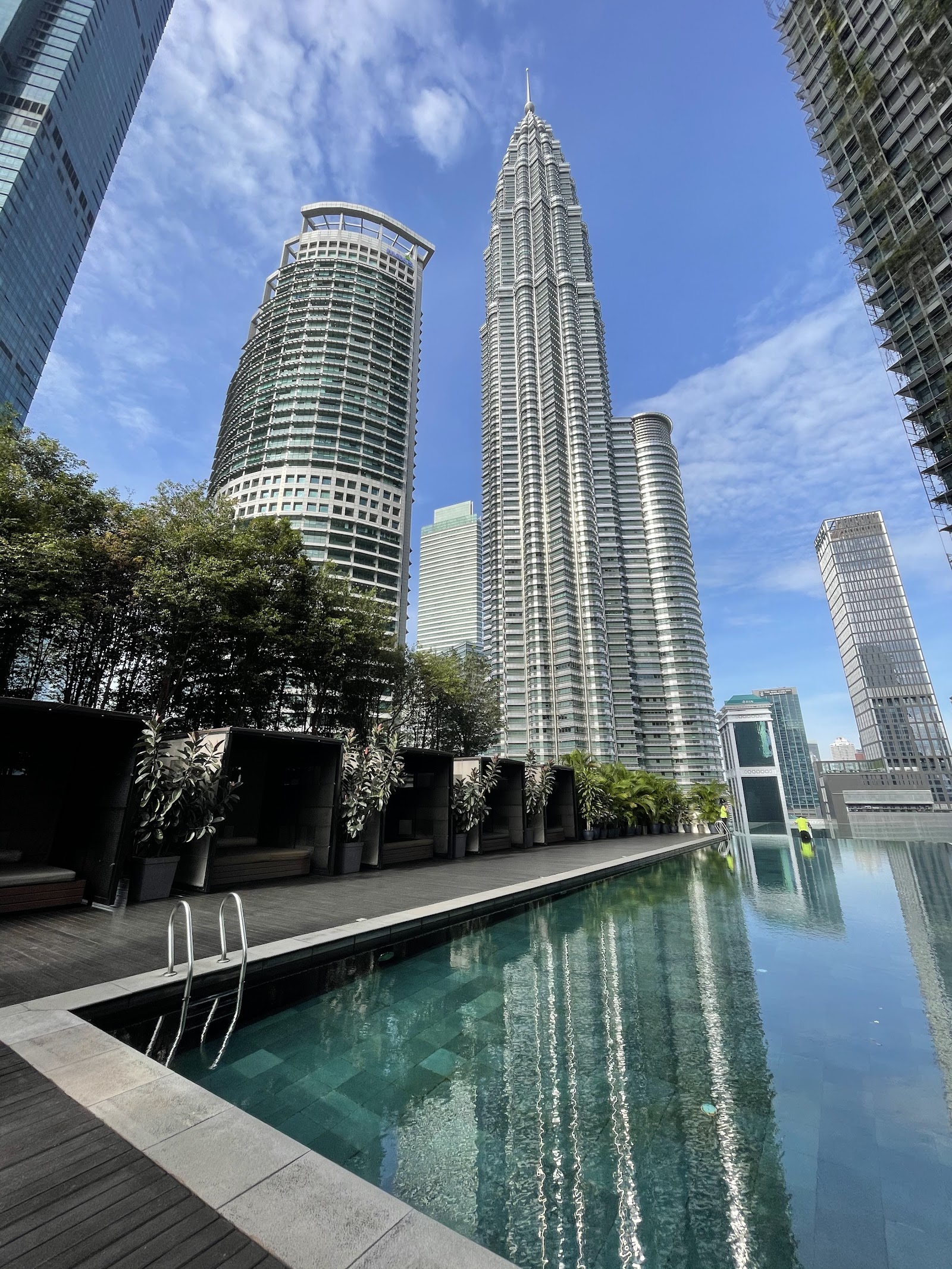 K Residence: A rooftop infinity pool and lounge area at K Residence, with the Petronas Twin Towers and other high-rise buildings visible in the background.