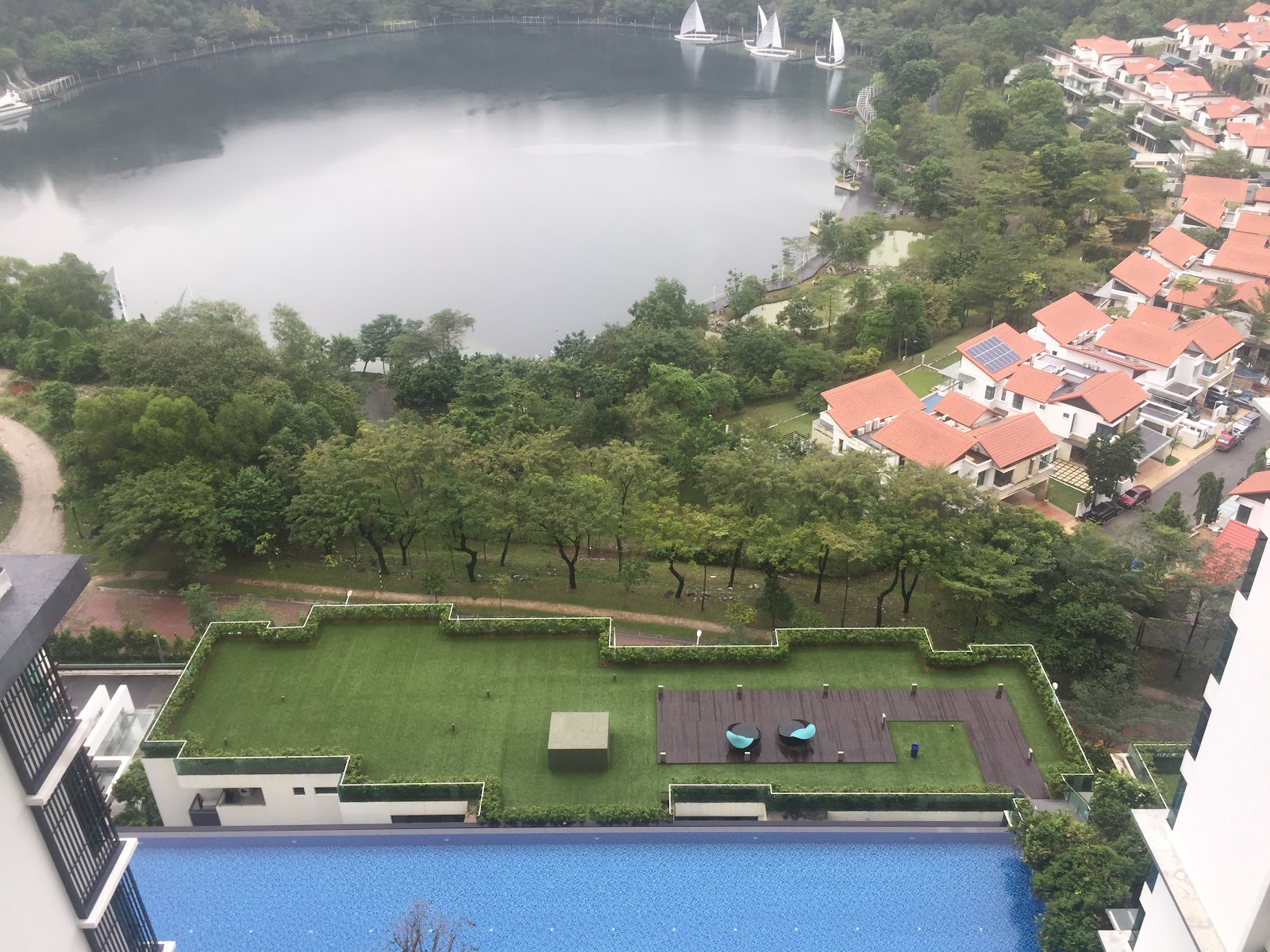 LaCosta, SUNWAY SOUTH QUAY: Aerial view from a penthouse terrace overlooking a lake with sailboats and a residential neighborhood with red roofs.