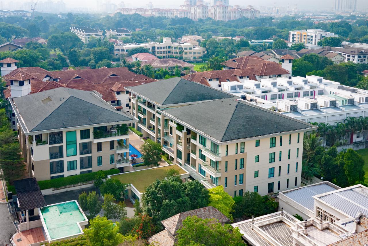 Madge Residences: Aerial view of the Madge Residences condominium buildings showing their facades and central swimming pool surrounded by lush greenery