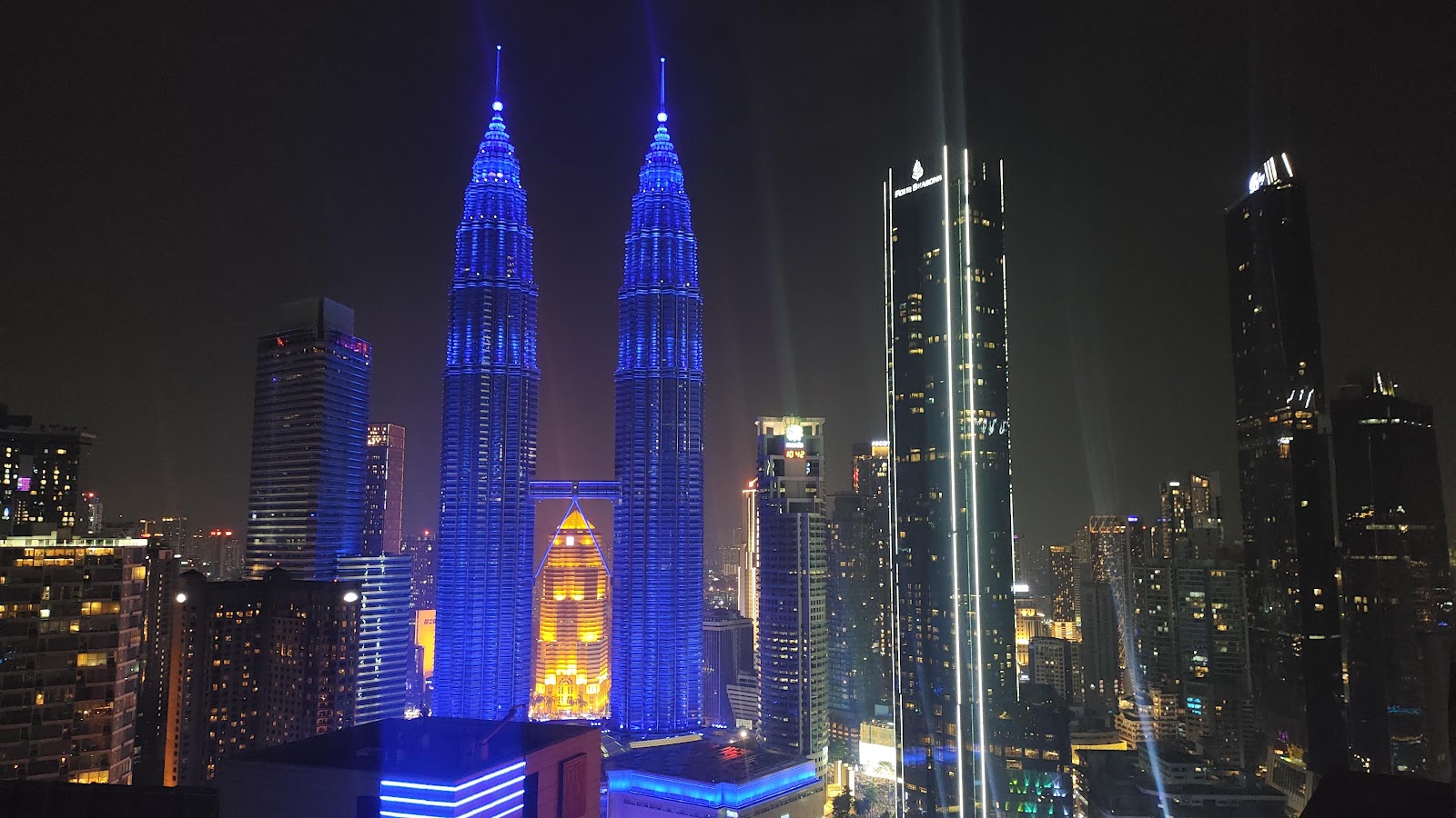 Quadro Residences: A night view of the Kuala Lumpur skyline featuring the illuminated Petronas Twin Towers and surrounding skyscrapers.