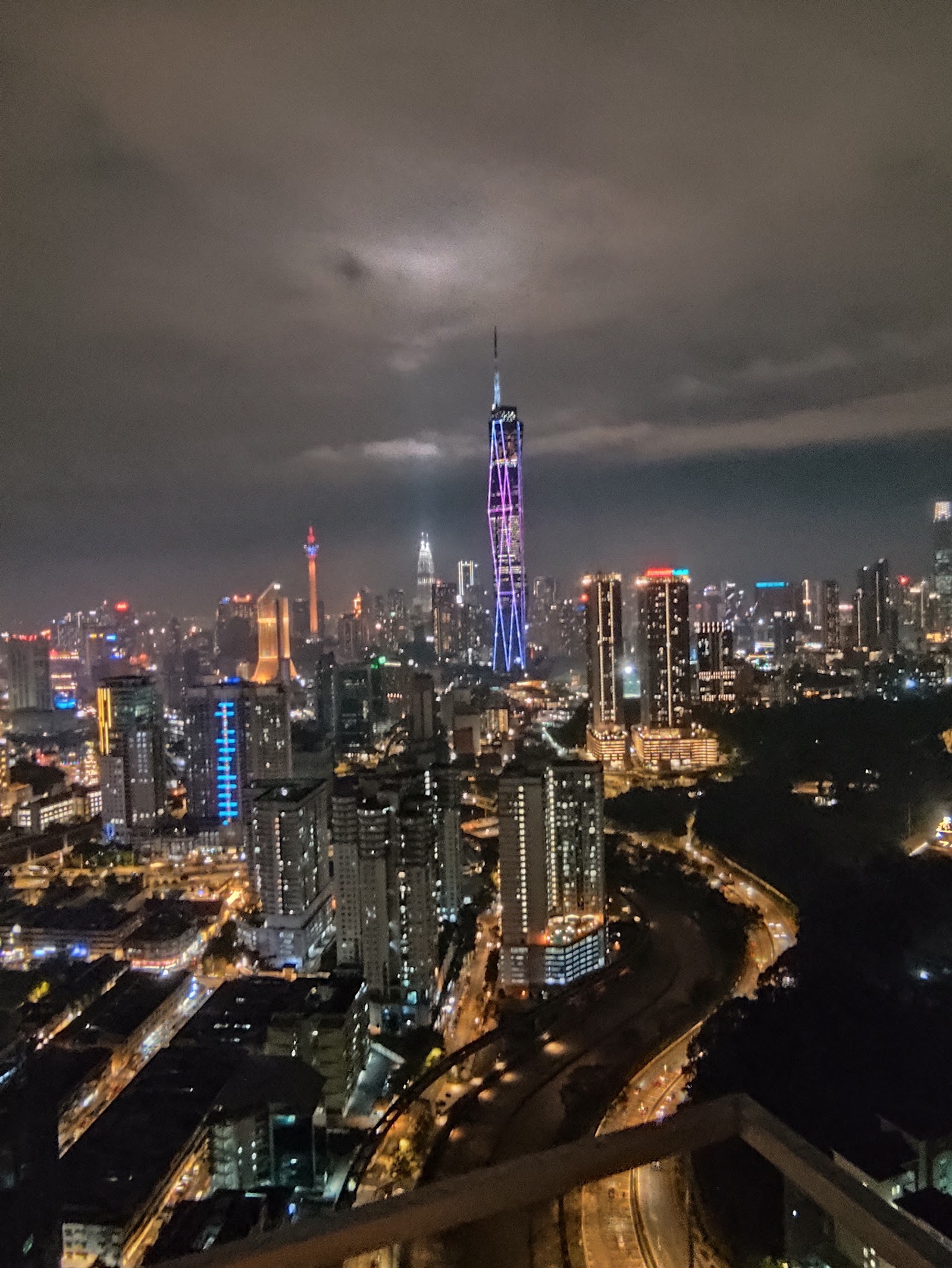 633 Residency: A wide-angle night view of the Kuala Lumpur city skyline featuring the illuminated Merdeka 118 and KL Tower, shot from an elevated outdoor vantage point.