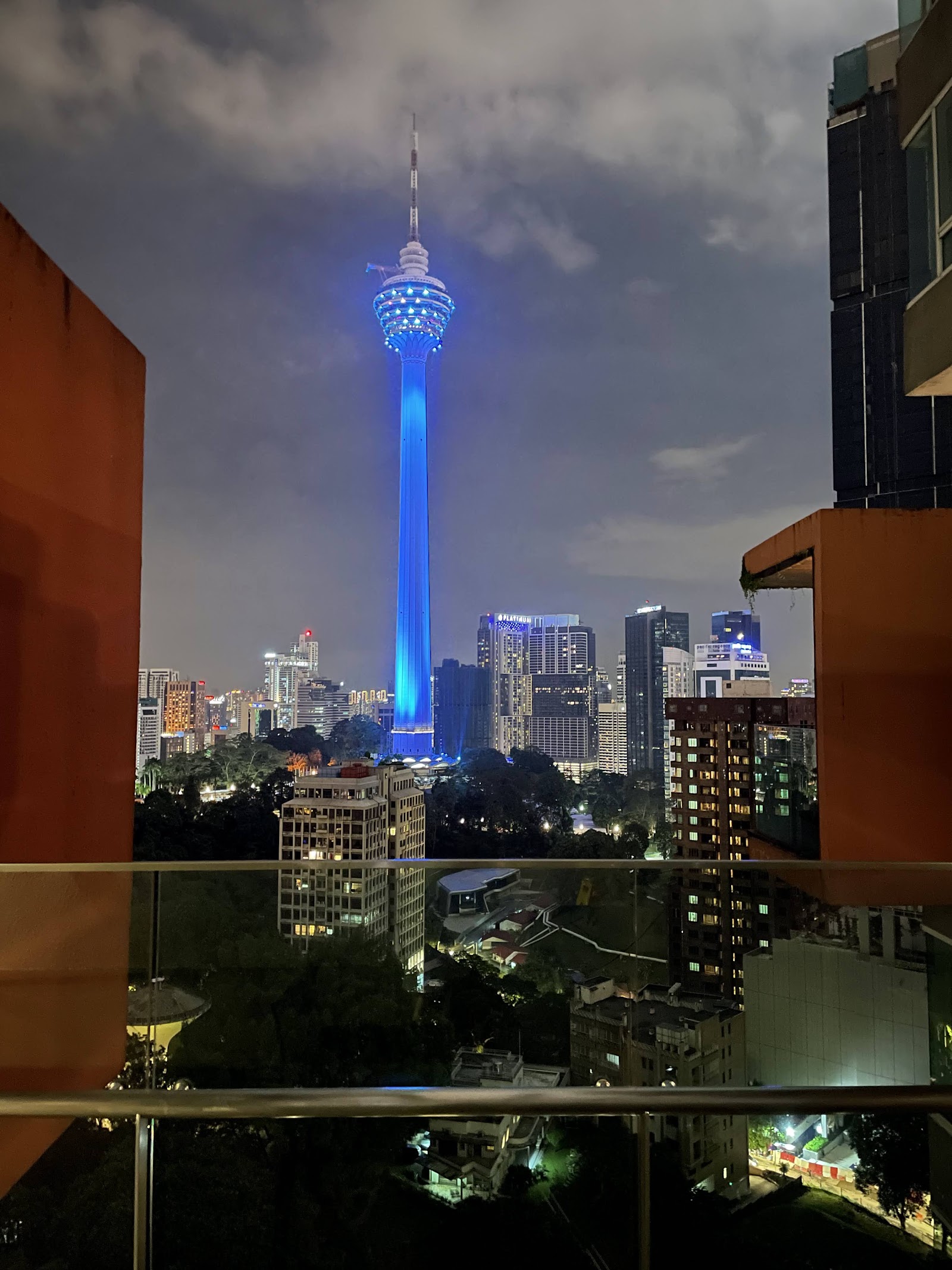 City Gardens Condominium: A night-time view of the Kuala Lumpur city skyline, featuring the blue-lit KL Tower, as seen from a balcony or window.